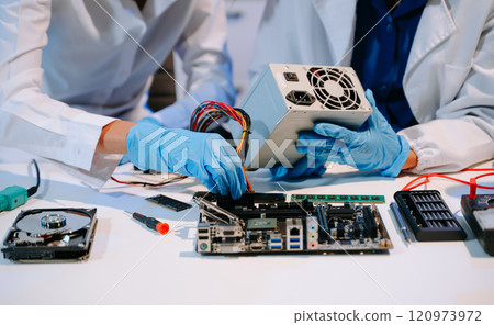 The technician is putting the CPU on the socket of the computer motherboard. electronic engineering 120973972