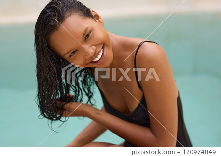 Smiling Woman with Wet Hair Relaxing by a Poolside in Swimwear Smiling Woman with Wet Hair Relaxing by a Poolside in Swimwear 120974049