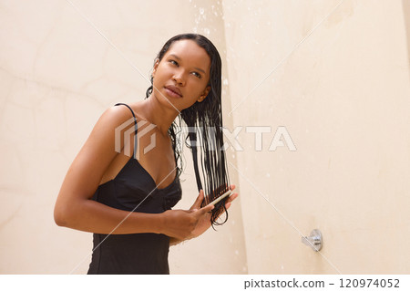 Woman with Long Hair Enjoying Refreshing Outdoor Shower Experience 120974052