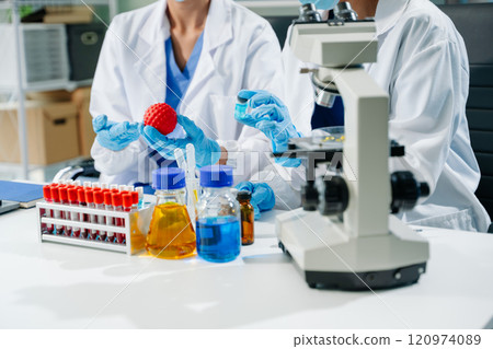 scientists in lab coats conducting research, handling glassware, and working with chemicals scientists in lab coats conducting research, handling glassware, and working with chemicals 120974089