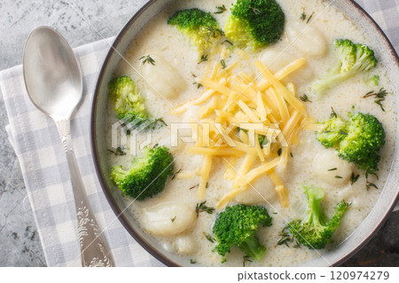Creamy broccoli gnocchi soup is delicious, warming and the ultimate winter comfort food closeup on the plate. Horizontal top view 120974279