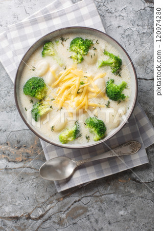 Broccoli Gnocchi cheddar soup rich, creamy, and packed with cheesy goodness closeup on the plate. Vertical top view 120974280