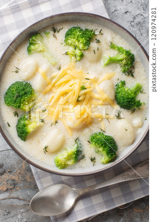 Broccoli and Cheese Soup with Gnocchi closeup on the plate. Vertical top view 120974281