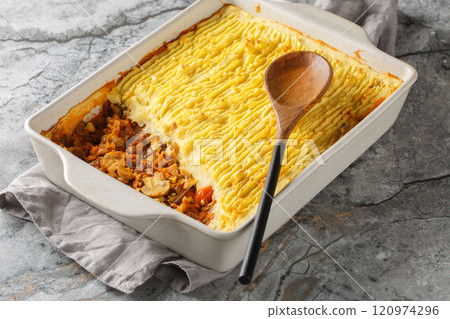 Hot healthy meatless shepherd's pie with lentils, onions, mushrooms, tomatoes, carrots close-up in a baking dish. Horizontal Hot healthy meatless shepherd's pie with lentils, onions, mushrooms, tomatoes, carrots close-up in a baking dish. Horizontal 120974296