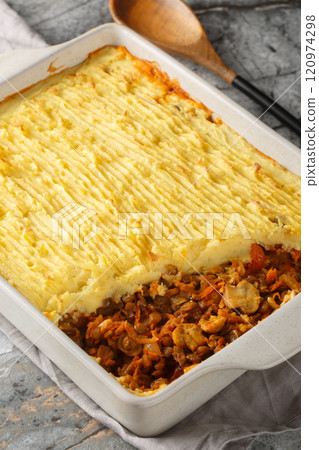 Vegan baked shepherd's pie with lentils, mushrooms and lots of vegetables close-up in a baking dish. Vertical Vegan baked shepherd's pie with lentils, mushrooms and lots of vegetables close-up in a baking dish. Vertical 120974298