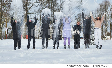 Cheerful schoolgirls having fun in a winter park, throwing snow and jumping together during their holiday break Cheerful schoolgirls having fun in a winter park, throwing snow and jumping together during their holiday break 120975226