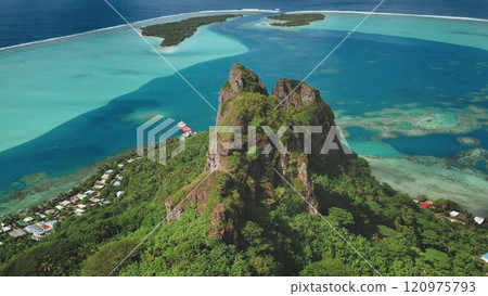Breathtaking aerial perspective Teurafaatiu mountain peak rising over vibrant turquoise ocean lagoon, coral reefs and Maupiti tropical island green slopes. Remote wild nature exotic travel background Breathtaking aerial perspective Teurafaatiu mountain peak rising over vibrant turquoise ocean lagoon, coral reefs and Maupiti tropical island green slopes. Remote wild nature exotic travel background 120975793