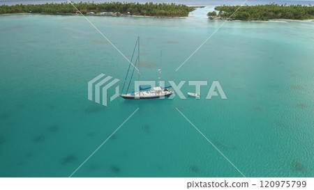 Aerial panorama white sailboat yacht with dinghy stand in turquoise water lagoon near tropical island with palm trees and white sand beaches. Remote wild nature paradise, exotic travel background 120975799