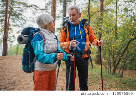 Hiking tourism adventure. Senior couple man woman enjoying outdoor recreation hiking in forest. Happy old people backpackers hikers enjoy walking hike trekking tourism active vacation beauty of nature Hiking tourism adventure. Senior couple man woman enjoying outdoor recreation hiking in forest. Happy old people backpackers hikers enjoy walking hike trekking tourism active vacation beauty of nature 120976899