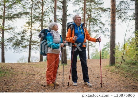 Hiking tourism adventure. Senior couple man woman enjoying outdoor recreation hiking in forest. Happy old people backpackers hikers enjoy walking hike trekking tourism active vacation beauty of nature Hiking tourism adventure. Senior couple man woman enjoying outdoor recreation hiking in forest. Happy old people backpackers hikers enjoy walking hike trekking tourism active vacation beauty of nature 120976900