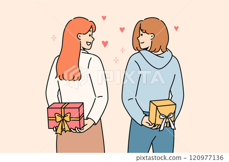 Positive girls hold gifts behind their backs and look at each other lovingly, showing sympathy 120977136