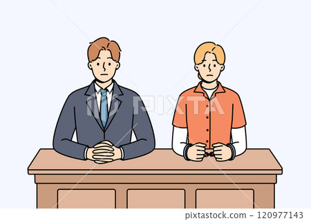 Man lawyer and woman defendant in handcuffs sit at table awaiting verdict from judge 120977143