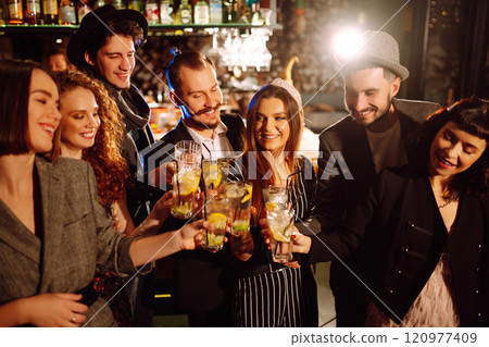 Cheering and drinking cocktails. Group of friends partying in nightclub, toasting drinks cocktails. Cheering and drinking cocktails. Group of friends partying in nightclub, toasting drinks cocktails. 120977409