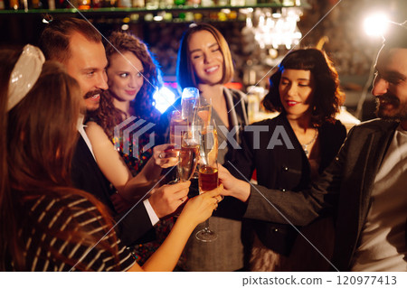 Cheering and drinking cocktails. Group of friends partying in nightclub, toasting drinks cocktails. Cheering and drinking cocktails. Group of friends partying in nightclub, toasting drinks cocktails. 120977413