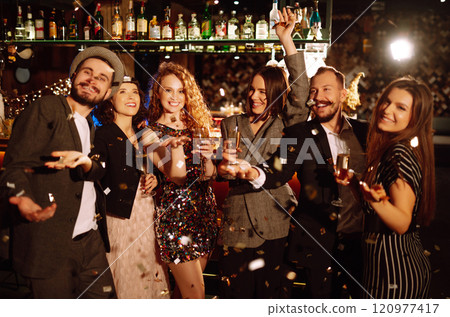 Happy friends throwing confetti, jumping while enjoying party. Confetti is fun. Party, celebration. 120977417
