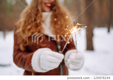 Happy woman with bengal light in her hand enjoying and have fun winter holidays among snowy landace. 120978244