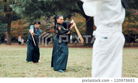 Sword, martial arts and people in outdoor class together for aikido training, fight coaching or samurai challenge in nature. Warrior, Japanese man and woman in park for traditional bokken battle kata Sword, martial arts and people in outdoor class together for aikido training, fight coaching or samurai challenge in nature. Warrior, Japanese man and woman in park for traditional bokken battle kata 120978683