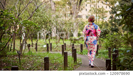 Back, Kimono and travel with woman in park to explore green location for sightseeing or tourism. Fashion, nature conservation and walking with person outdoor in Japan for culture, holiday or vacation 120978690
