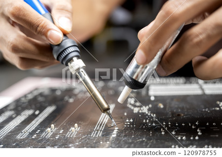 Man technician soldering a circuit board 120978755