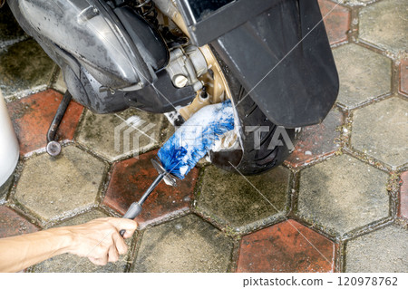 Professional worker hand washing the motorcycle with cleaning foam 120978762