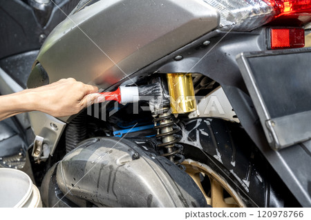 Professional worker hand washing the motorcycle with cleaning foam 120978766