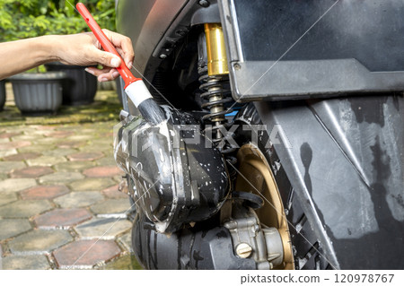 Professional worker hand washing the motorcycle with cleaning foam Professional worker hand washing the motorcycle with cleaning foam 120978767
