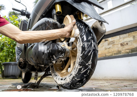 Professional worker hand washing the motorcycle with cleaning foam 120978768