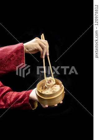 Chinese person with chopstick eating dim sum dumpling on bamboo wooden basket bowl Chinese person with chopstick eating dim sum dumpling on bamboo wooden basket bowl 120978812