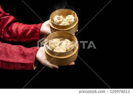 Chinese person holding dim sum dumpling on bamboo wooden basket bowl 120978813