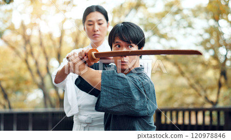 City, bamboo sword and Asian man with instructor for martial arts, Kendo practice and exercise. Culture, heritage and person with shinai, bokuto and weapon for skill, fight and training in Japan 120978846