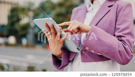 Online, hands and person with tablet in street for social networking, reading ebook and travel location search. Japan, scroll or technology for internet research, web information or streaming service 120978854