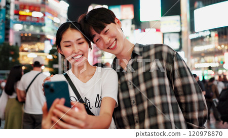 Couple, selfie and night in city with smile for date, memory and travel with bonding for post on web. People, woman and man with photography, happy and profile picture on social network in Japan Couple, selfie and night in city with smile for date, memory and travel with bonding for post on web. People, woman and man with photography, happy and profile picture on social network in Japan 120978870
