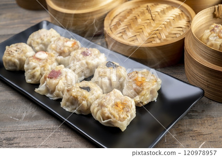 Assorted chinese dim sum dumpling on the plate with bamboo wooden basket bowl on wooden table 120978957