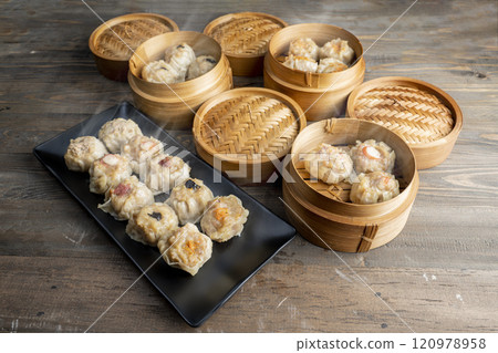 Assorted chinese dim sum dumpling on the plate with bamboo wooden basket bowl on wooden table Assorted chinese dim sum dumpling on the plate with bamboo wooden basket bowl on wooden table 120978958