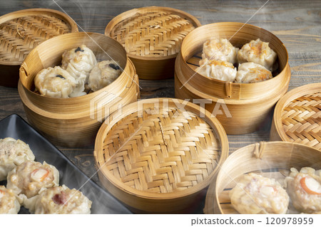 Assorted chinese dim sum dumpling on the plate with bamboo wooden basket bowl on wooden table Assorted chinese dim sum dumpling on the plate with bamboo wooden basket bowl on wooden table 120978959