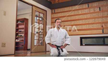 Martial arts, kneeling and Japanese man with respect, honor and karate etiquette in dojo. Japan, combat training and fight studio with sport, discipline and warrior in taekwondo class in gym Martial arts, kneeling and Japanese man with respect, honor and karate etiquette in dojo. Japan, combat training and fight studio with sport, discipline and warrior in taekwondo class in gym 120979049