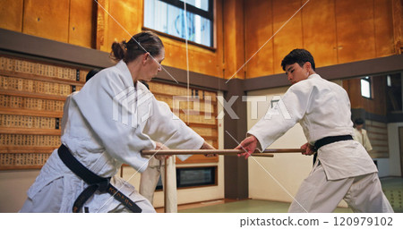Dojo, class and strike partner at Aikido training in gym with wood sword Japanese martial arts and fight exercise in studio. Learning, sport and bamboo weapon with people and practice for defence Dojo, class and strike partner at Aikido training in gym with wood sword Japanese martial arts and fight exercise in studio. Learning, sport and bamboo weapon with people and practice for defence 120979102