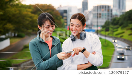 Fitness, happy friends and women with phone in city for social media, training app or show text. Japanese girls, sports and outdoor with mobile for body health, exercise results or tracking wellness 120979137