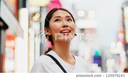 Japanese woman, view and city with travel, outdoor and sightseeing with smile from thinking. Happy, holiday and idea for vacation and urban journey in Tokyo with town trip and adventure break 120979241