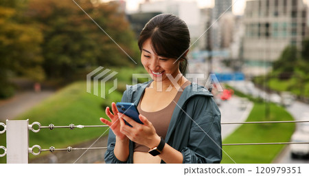 Cellphone, fitness and woman outdoor with online exercise plan for running, wellness and training. Happy, sports and Japanese female athlete on phone with mobile health tracker app for cardio workout 120979351