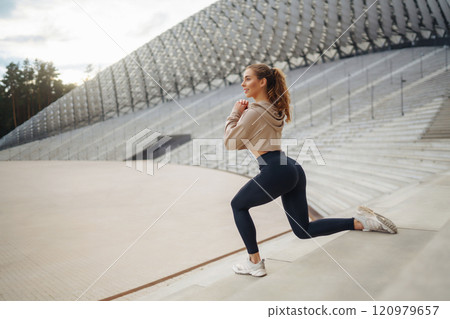 Active lifestyle. Young fitness woman exercising and stretching outdoors. Sports, sports training. 120979657