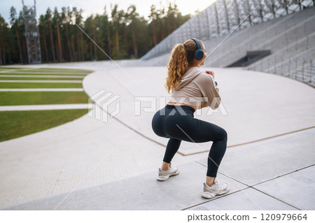Active lifestyle. Young fitness woman exercising and stretching outdoors. Sports, sports training. 120979664