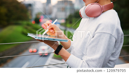 Hands, person and writing on tablet in city for copywriting, reading article and publishing process. Writer, headphones and pen of newsletter blog of story, editing update and project on Japan bridge 120979705