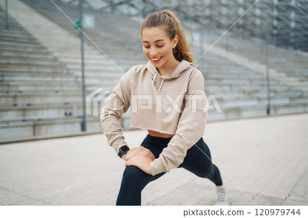 Active lifestyle. Young fitness woman exercising and stretching outdoors. Sports, sports training. 120979744