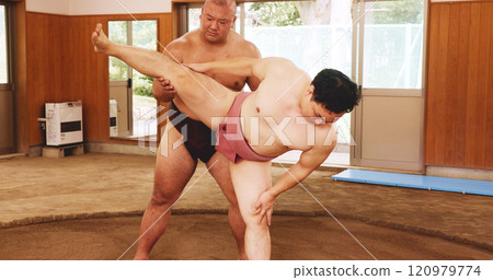 Men, ring and stretching in Japan for sumo, fitness and exercise with preparation, skill and technique. Japanese athlete, fighter and sports in dohyo for training, workout and wrestling with warm up 120979774