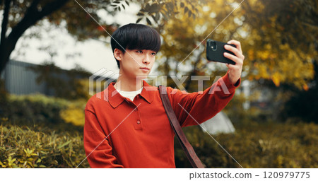 Selfie, influencer and man in park with social media, outdoor live streaming or online communication. Nature, photography and Japanese streamer with content creation, networking or web connectivity 120979775