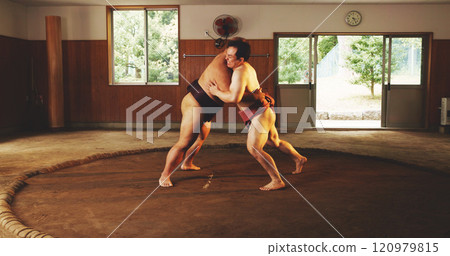 Combat, fighting or Sumo wrestling with men in dohyo for Japanese competition, culture or tournament. Exercise, fitness or training with wrestler and rival in ring of arena for exhibition match 120979815