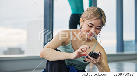 Phone, smile and woman in dance studio with networking, communication or browsing social media. Happy, cellphone and Japanese ballerina watching online video for classic technique at rehearsal. 120979888