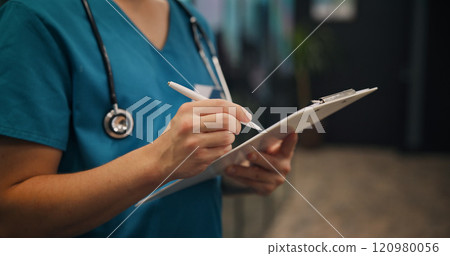 Hands, person and surgeon writing on clipboard at clinic for medical referral, diagnosis report and insurance. Nurse, document and healthcare of checklist, prescription and surgery schedule in Japan 120980056