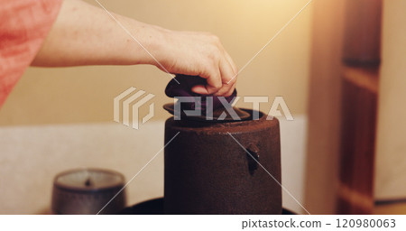 Hand, Japanese tea and teapot in home, traditional and matcha with antioxidants, ceremony and herbal. House, person and beverage to detox, health benefits and recipe for ocha, indigenous and Japan 120980063